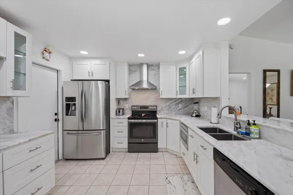 a kitchen with white cabinets stainless steel appliances and a sink