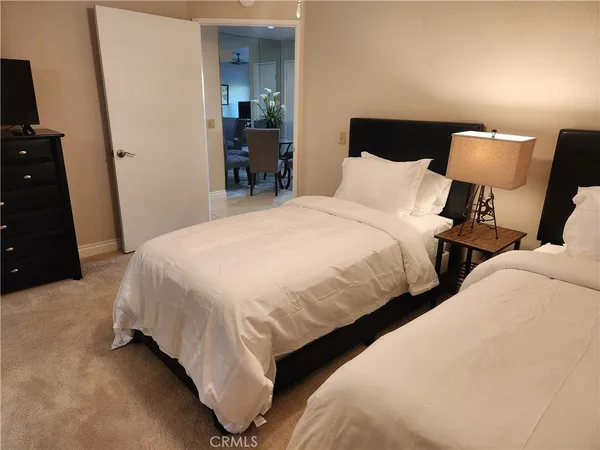 a bedroom with two beds and chair