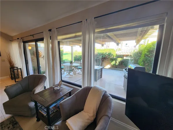 a living room with furniture and a floor to ceiling window