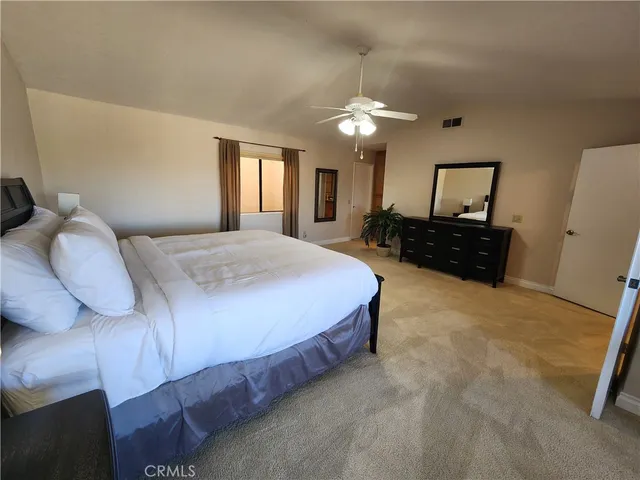 a bedroom with a bed window and dresser