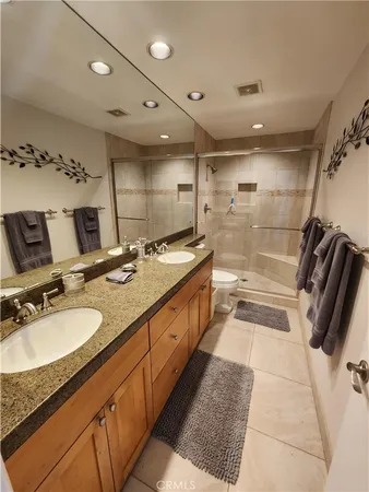 a bathroom with a granite countertop sink a mirror and a shower