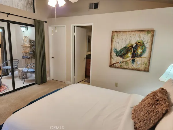 a bedroom with a large bed and a painting on the wall