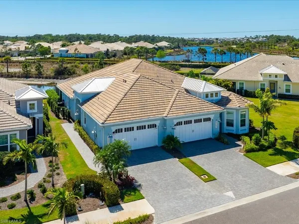 an aerial view of a house with a yard and lake view