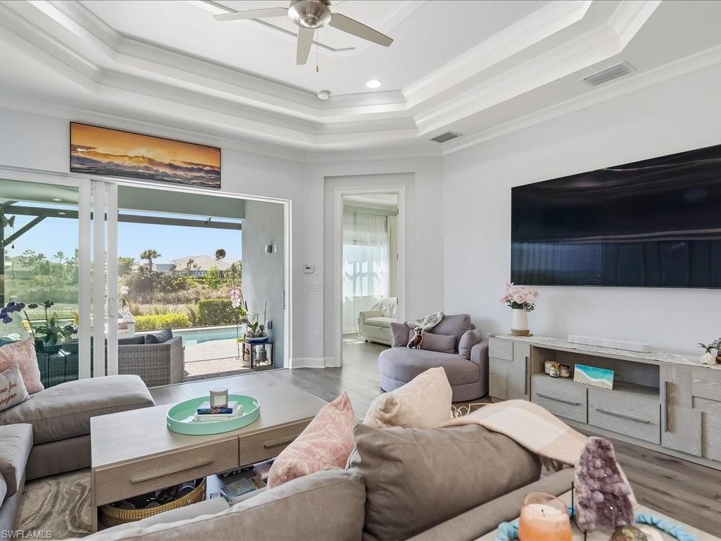6827 Saona Court Naples, FL 34113 - Photo 16 of 36 a living room with furniture and a flat screen tv