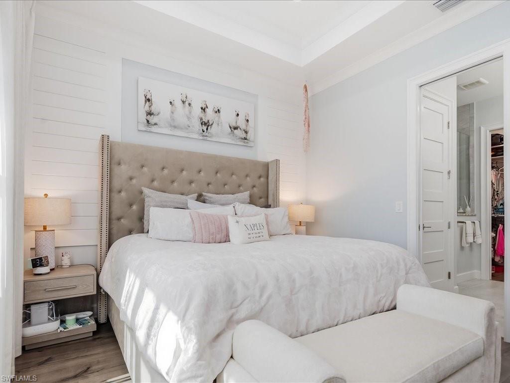 6827 Saona Court Naples, FL 34113 - Photo 20 of 36 a bedroom with a bed and a lamp