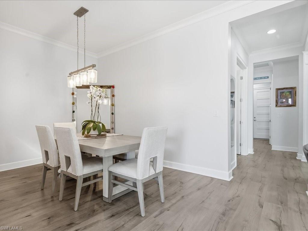 6827 Saona Court Naples, FL 34113 - Photo 24 of 36 a view of a dining room with furniture window and wooden floor