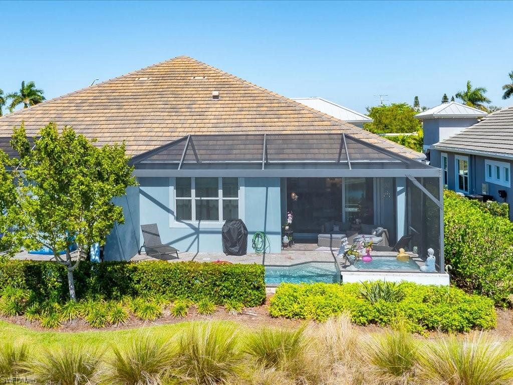 6827 Saona Court Naples, FL 34113 - Photo 30 of 36 a front view of a house with swimming pool and glass windows