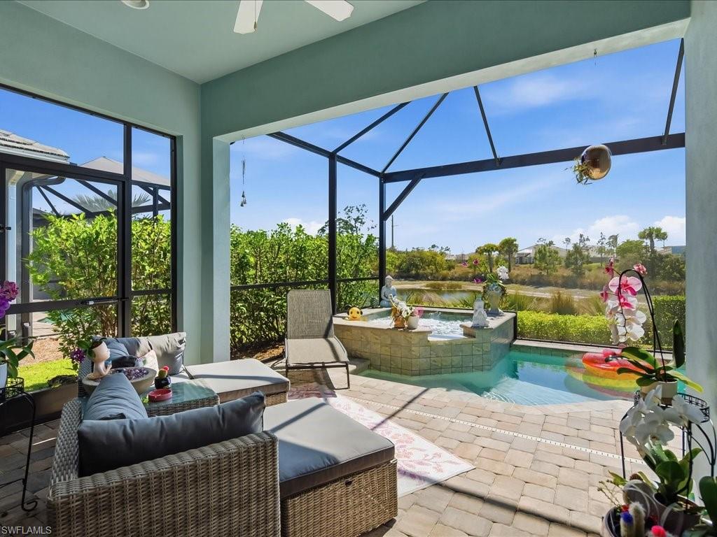 6827 Saona Court Naples, FL 34113 - Photo 5 of 36 a living room with patio furniture and a yard