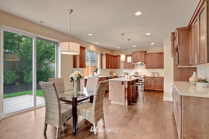 3731 226th Place Southeast Bothell, WA 98021 - Photo 10 of 16 a dining room with stainless steel appliances kitchen island granite countertop a refrigerator a sink a stove and a cabinets with wooden floor