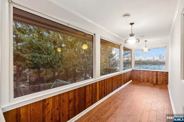 a view of a room with wooden floor and large windows