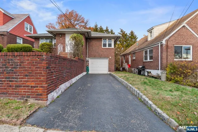 a front view of a house with a yard and potted plants