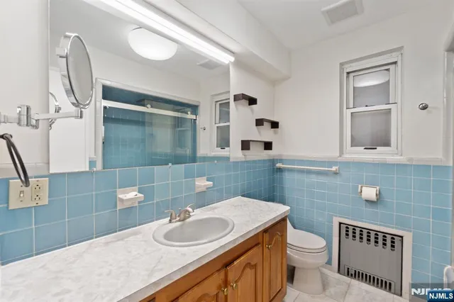 a bathroom with a granite countertop toilet sink and mirror
