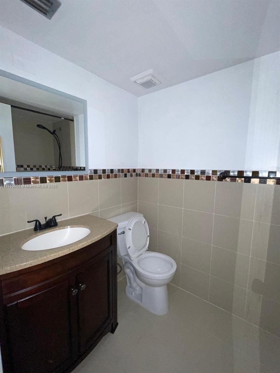 3410 Foxcroft Road, Unit 310 Miramar, FL 33025 - Photo 15 of 21 a bathroom with a toilet sink mirror vanity and shower