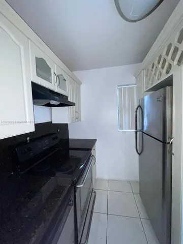 a kitchen with granite countertop white cabinets and black appliances