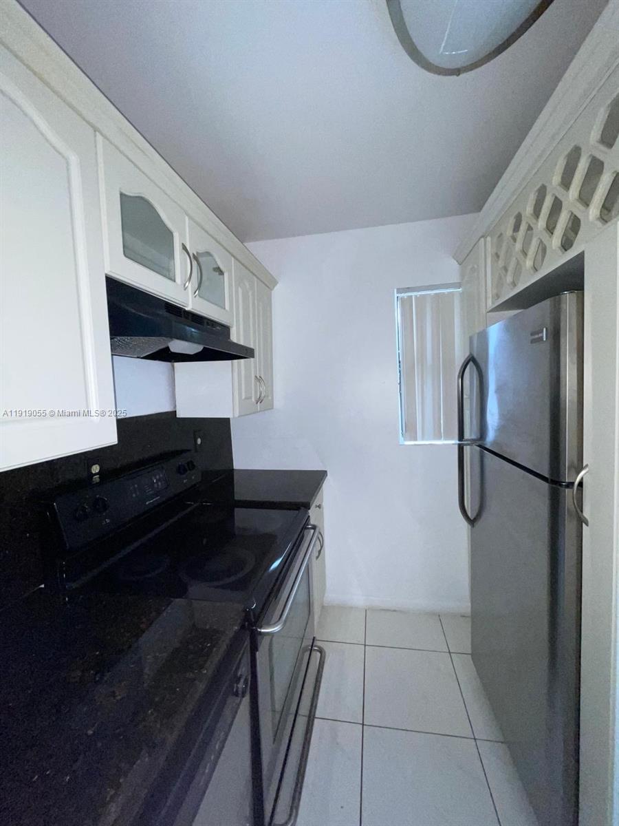 3410 Foxcroft Road, Unit 310 Miramar, FL 33025 - Photo 16 of 21 a kitchen with a refrigerator a stove and cabinets
