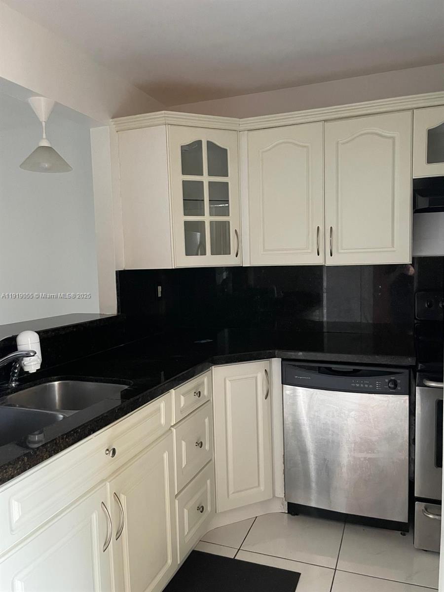 3410 Foxcroft Road, Unit 310 Miramar, FL 33025 - Photo 17 of 21 a kitchen with granite countertop white cabinets and black appliances