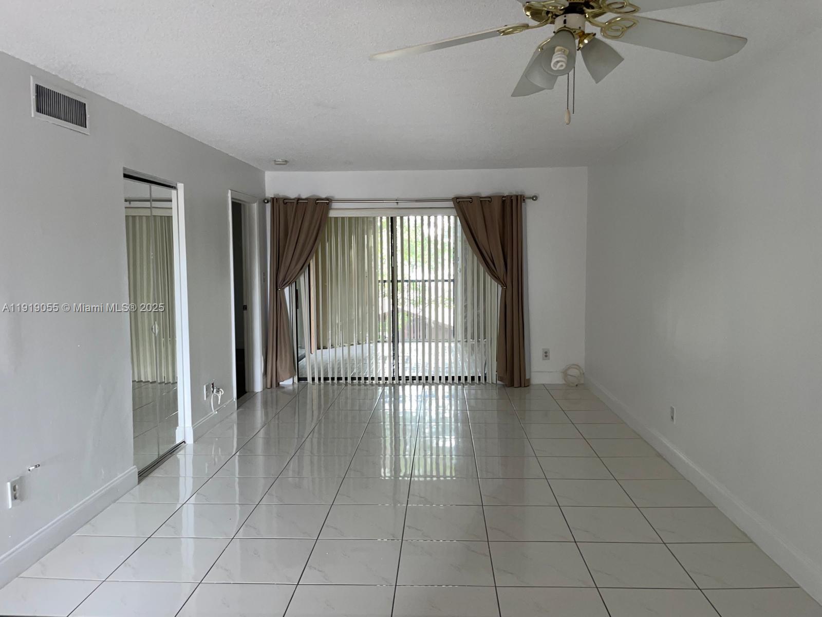 3410 Foxcroft Road, Unit 310 Miramar, FL 33025 - Photo 18 of 21 an empty room with chandelier fan and windows