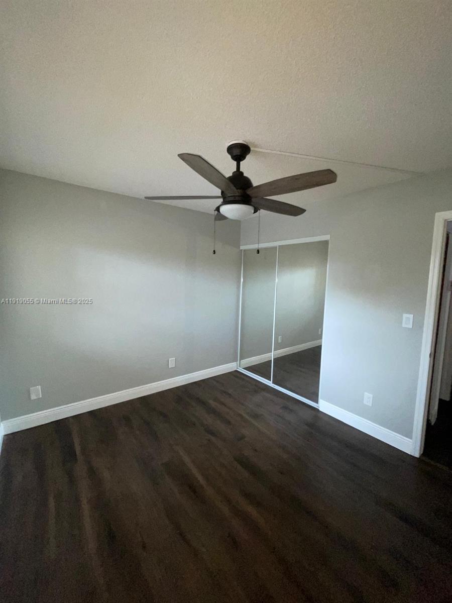 3410 Foxcroft Road, Unit 310 Miramar, FL 33025 - Photo 6 of 21 an empty room with wooden floor fan and windows