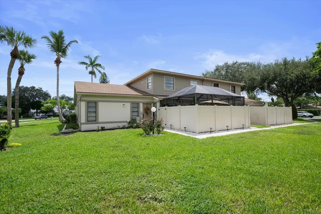 a front view of a house with a garden and trees