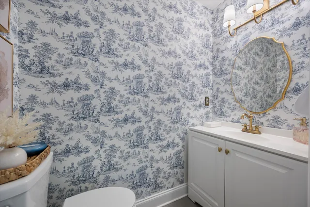 a bathroom with a granite countertop toilet sink and mirror