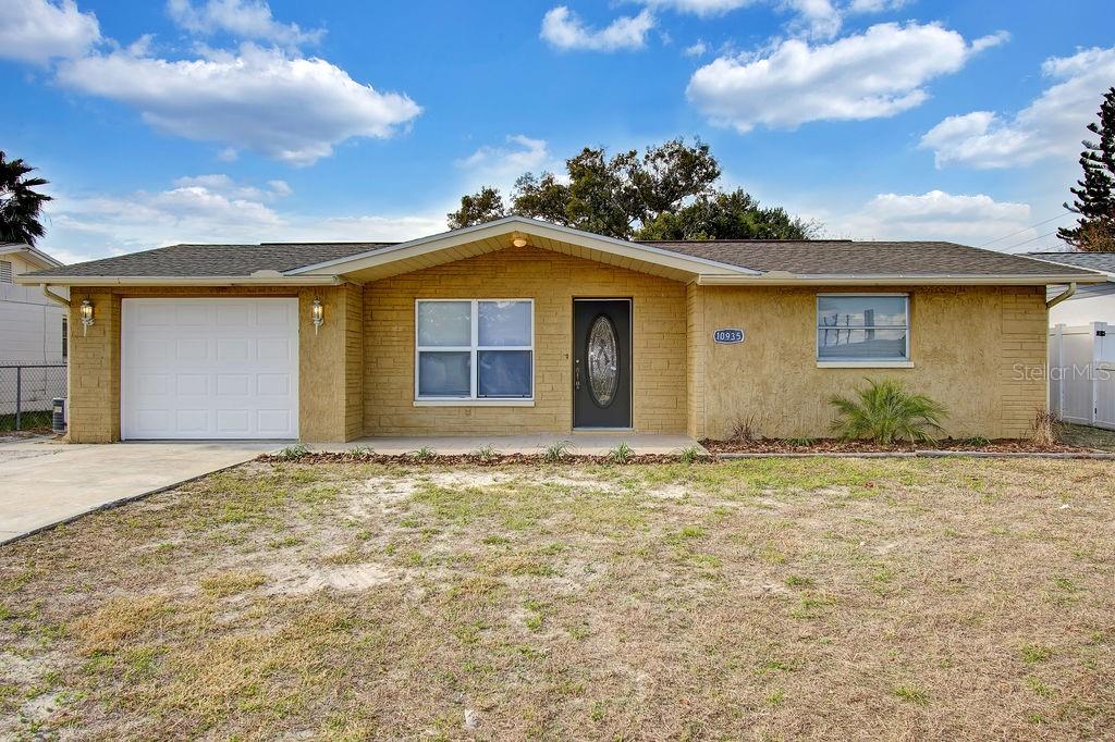 10935 Rexdale Avenue Port Richey, FL 34668 - Photo 1 of 1 front view of a house with a yard