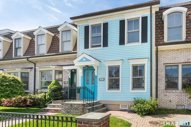 front view of a brick house with a small yard