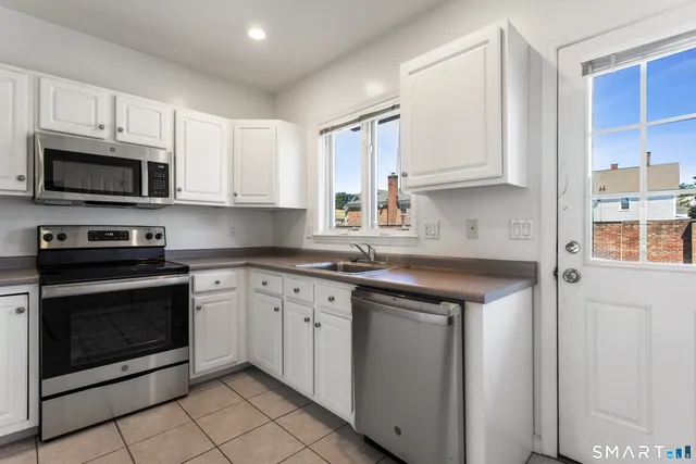 a kitchen with stainless steel appliances granite countertop a sink a stove a microwave and cabinets