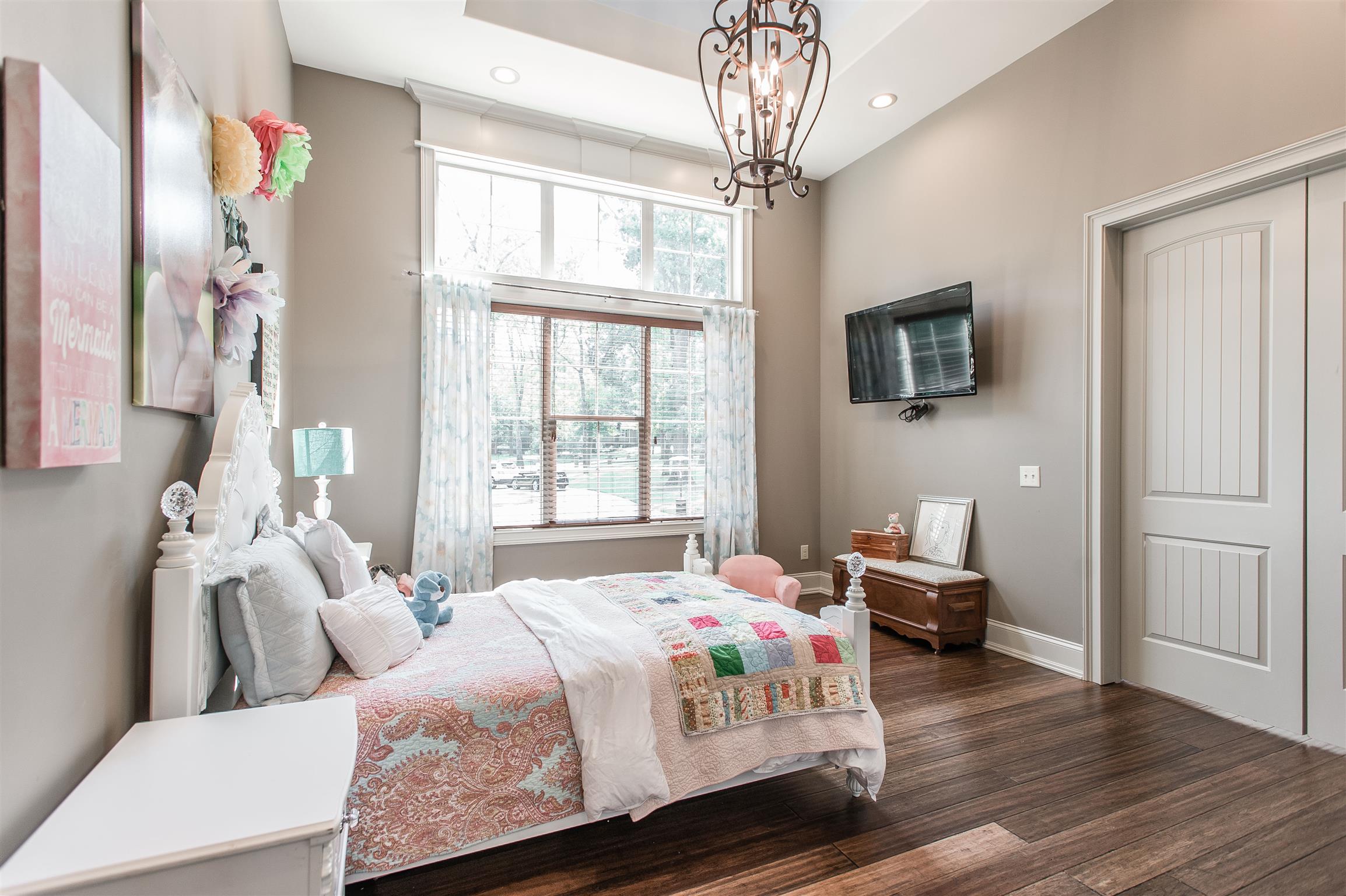 148 Cherokee Road Hendersonville, TN 37075 - Photo 17 of 30 a bedroom with a bed a chandelier and a flat tv screen