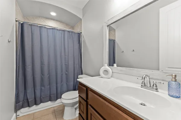 a bathroom with a sink a toilet and shower curtain