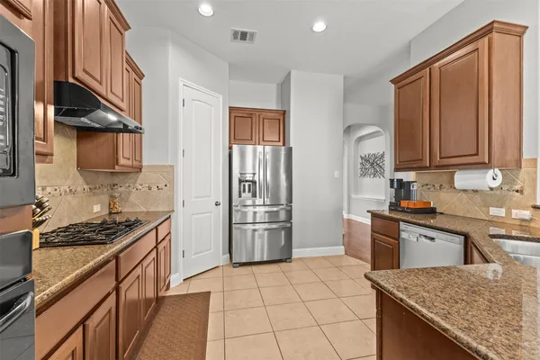 a kitchen with stainless steel appliances granite countertop a sink stove and refrigerator