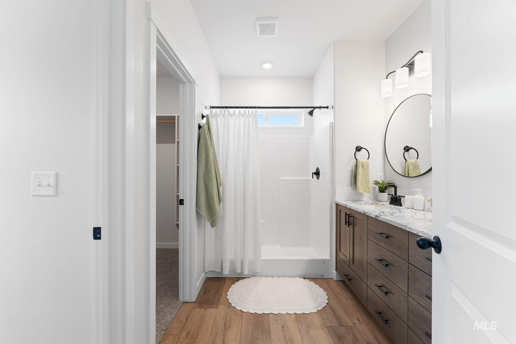 2220 Great Basin Way Burley, ID 83318 - Photo 21 of 39 Bathroom featuring a shower stall, light wood-style flooring, and vanity