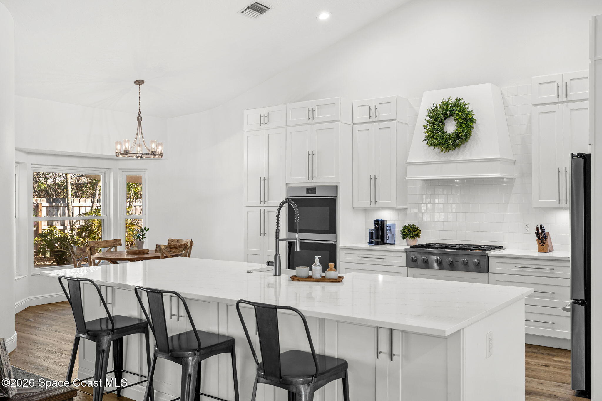 482 Veracruz Boulevard Indialantic, FL 32903 - Photo 14 of 45 a kitchen with stainless steel appliances kitchen island granite countertop a table and chairs in it