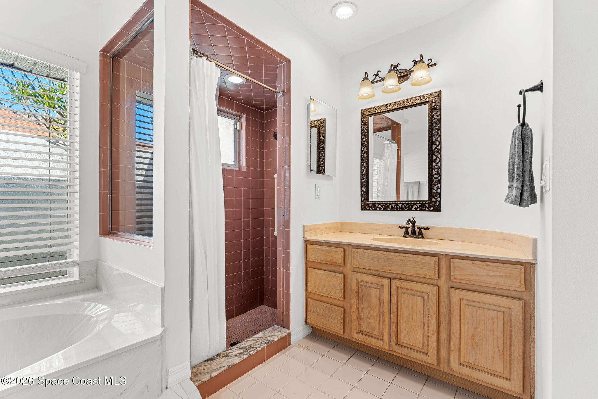 482 Veracruz Boulevard Indialantic, FL 32903 - Photo 21 of 45 a bathroom with a double vanity sink a mirror and a bathtub