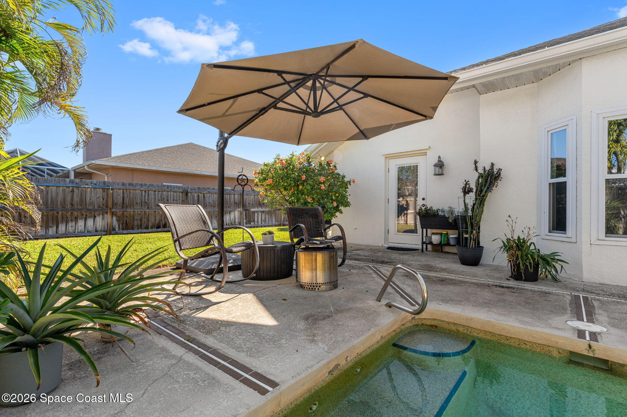 482 Veracruz Boulevard Indialantic, FL 32903 - Photo 33 of 45 a view of a patio with couches table and chairs under an umbrella