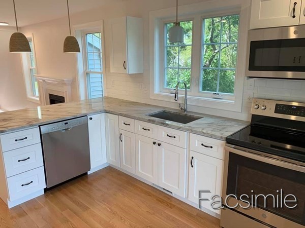40 Lafayette Road, Unit 2 Salisbury, MA 01952 - Photo 7 of 31 a kitchen with granite countertop a stove a sink and a microwave