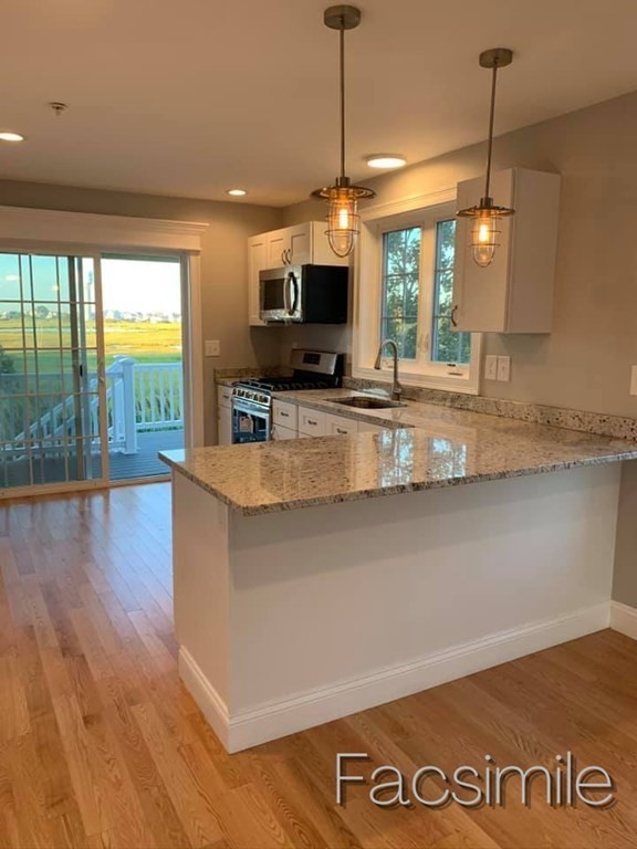 40 Lafayette Road, Unit 2 Salisbury, MA 01952 - Photo 10 of 31 a view of a kitchen with kitchen island a counter top space a sink and a large window