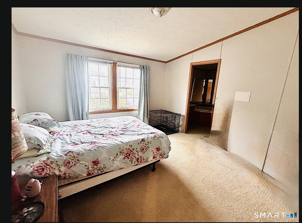 11 Circle Drive Windham, CT 06256 - Photo 7 of 18 a bedroom with a bed and a refrigerator