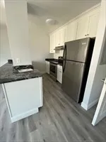 a kitchen with a refrigerator sink stove and cabinets