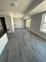 a view of an empty room and a kitchen