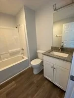 a bathroom with a granite countertop sink toilet a large mirror and shower