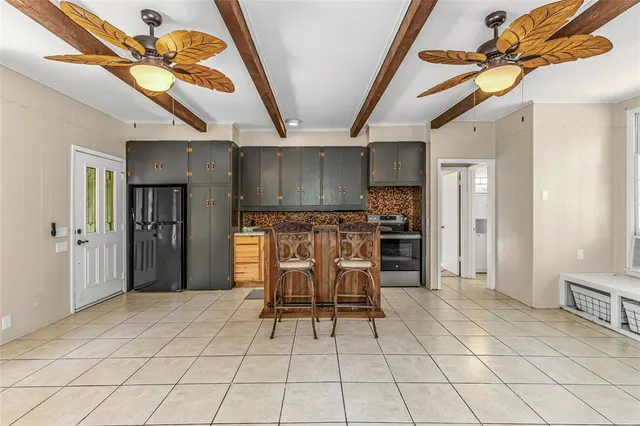 a view of kitchen with stainless steel appliances kitchen island granite countertop a refrigerator and cabinets