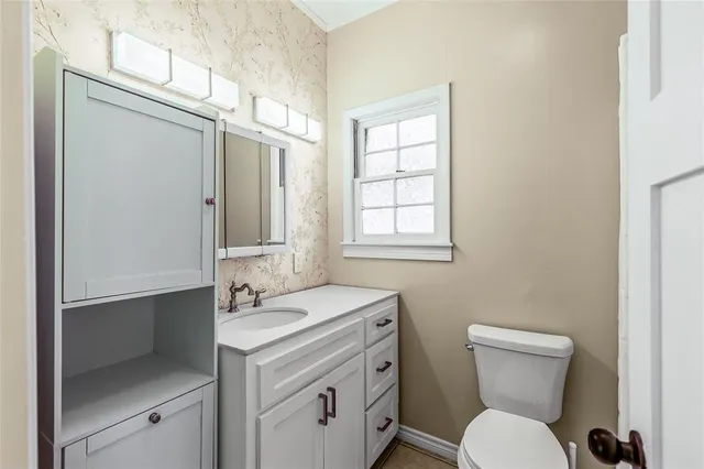 a bathroom with a toilet a sink and a window