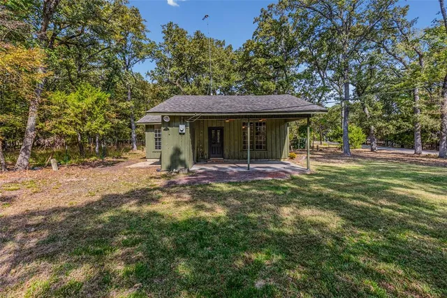 a backyard of a house with plants and wooden fence