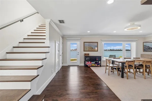 a living room with furniture pool table wooden floor and windows