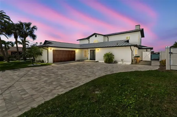 a living room with couches and kitchen view with wooden floor