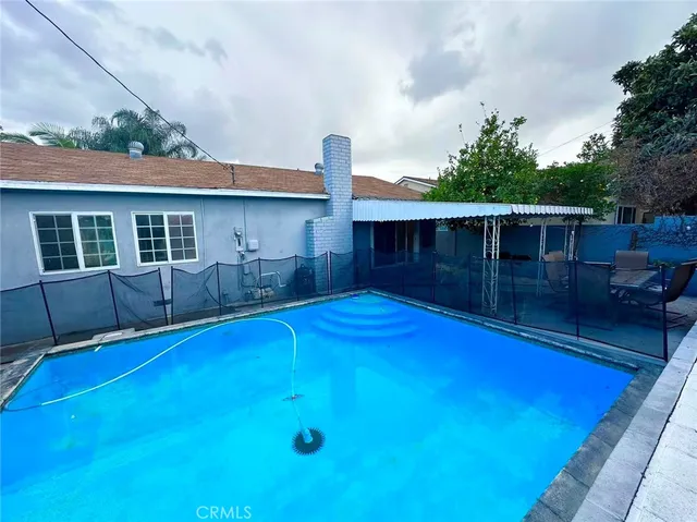 a view of a house with pool and chairs