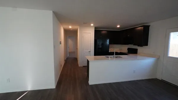 a view of kitchen with stainless steel appliances wooden floor and large window
