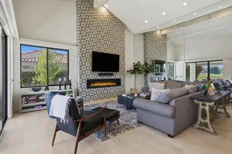 a living room with furniture a fireplace and a flat screen tv