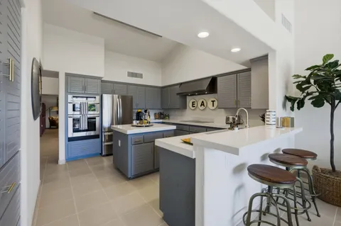 a kitchen with a sink a stove and chairs