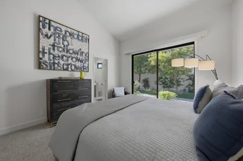 a bedroom with a bed and a dresser next to a window